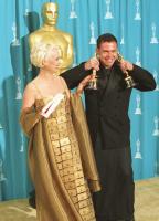 Lizzy Gardiner (con un traje compuesto de tarjetas American Express) y Tim Chappel tras recoger su Oscar a mejor vestuario